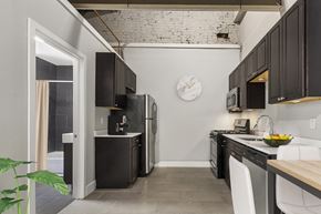 Philadelphia apartment for rent - A kitchen with black cabinets and a white wall with a clock on it.
