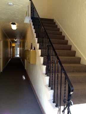 Los Angeles apartment for rent - A staircase with a black railing and beige carpeting.