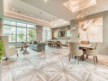 The Woodlands apartment for rent - A living room with a large rug and a dining table with chairs.