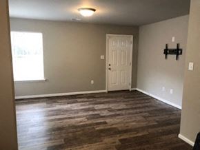 Lexington apartment for rent - an empty living room with a white door and wood floors