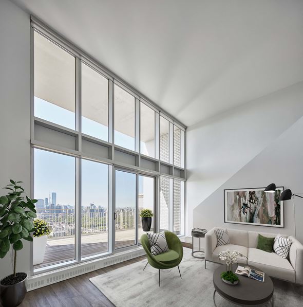 Toronto apartment for rent - a living room with large windows and a couch and a chair