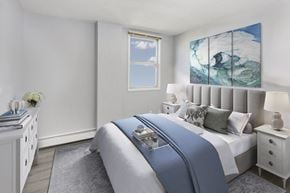 Calgary apartment for rent - bedroom with a bed, lamp, window and curtains