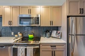 Boston apartment for rent - a kitchen with stainless steel appliances and white cabinets