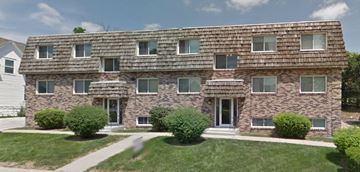 Omaha apartment for rent - an apartment building with a brick facade and a wooden roof