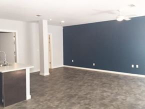 Jackson apartment for rent - an empty living room with a blue wall and a kitchen