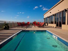 Jackson apartment for rent - a swimming pool with red chairs next to a house