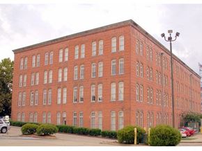 Shreveport apartment for rent - A red brick building with a parking lot in front.