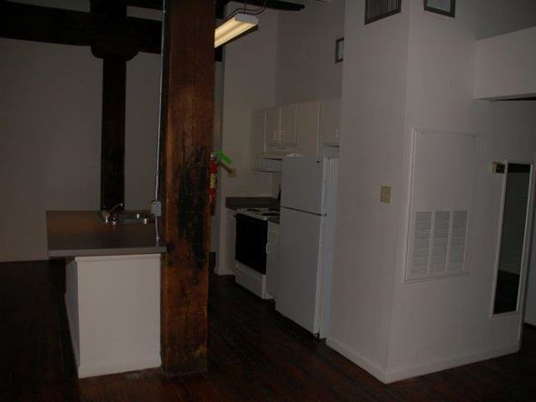 Shreveport apartment for rent - A kitchen with white appliances and a wooden beam.