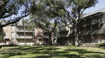 New Orleans apartment for rent - A tree in front of a building with a balcony.
