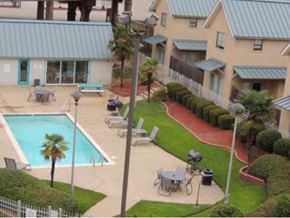 Shreveport apartment for rent - A pool surrounded by chairs and a fence.