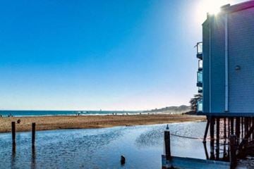 Santa Cruz apartment for rent - A sunny day at the beach with a building on the right side.