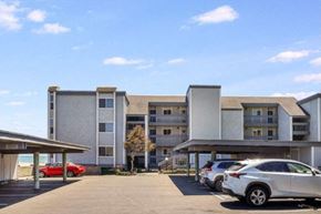 Santa Cruz apartment for rent - A parking lot in front of a multi-story apartment building with cars parked.