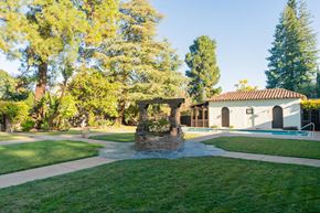 Palo Alto apartment for rent - a stone gazebo in a yard with a pool and trees