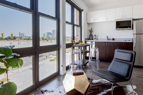 West Sacramento apartment for rent - a living room with a large window and a kitchen with a city view