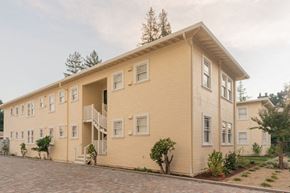 Palo Alto apartment for rent - a yellow apartment building with a street in front of it