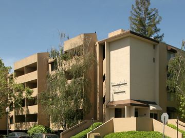 Palo Alto apartment for rent - a large tan building with trees in front of it