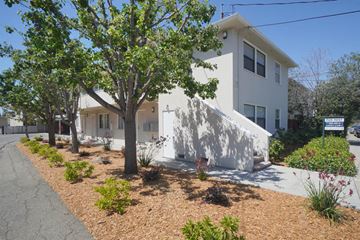 Palo Alto apartment for rent - a white house with a sidewalk and trees in front of it