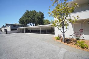 Palo Alto apartment for rent - an empty parking lot in front of a white building