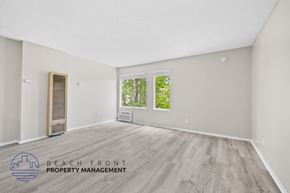 Santa Ana townhouse for rent - A spacious room with a wooden floor and a window overlooking greenery.