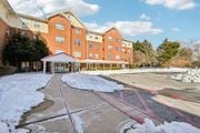 Perryville apartment for rent - A large red brick building with a white roof and a covered walkway.