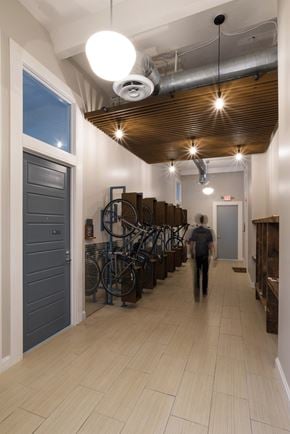 Pittsburgh apartment for rent - a man is walking down a hallway with bikes in a building