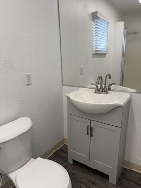 Modesto house for rent - A white toilet sits next to a sink in a small bathroom.