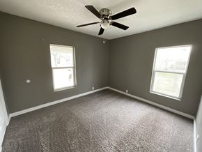 Abilene apartment for rent - A room with a ceiling fan and two windows.