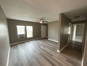 Abilene apartment for rent - A room with a ceiling fan and a window overlooking a parking lot.