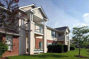 Fort Wayne apartment for rent - a white and brick apartment building with a green yard