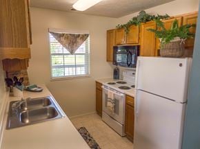 Fishers apartment for rent - a kitchen with white appliances and wooden cabinets