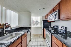 St. Paul apartment for rent - A kitchen with black countertops and white appliances at Lowertown Commons Apartments, St. Paul