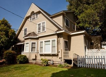 Palo Alto apartment for rent - a yellow house with a white fence in front of it