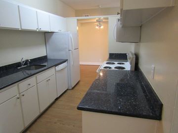 San Jose apartment for rent - a kitchen with white cabinets and black counter tops
