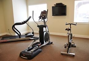Ogden townhouse for rent - a home gym with exercise equipment and a television