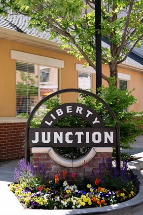Ogden townhouse for rent - Liberty Junction Apartments, Ogden, Utah, Entrance with flowers, exterior sign.