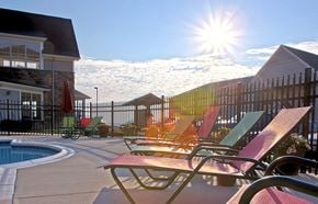 Staunton apartment for rent - A sunny day at the pool with chairs and a fence.