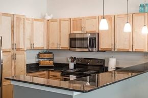 Staunton apartment for rent - A kitchen with wooden cabinets and a black countertop.
