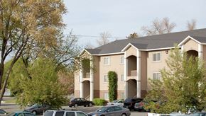 Rexburg apartment for rent - an apartment building with cars parked in a parking lot