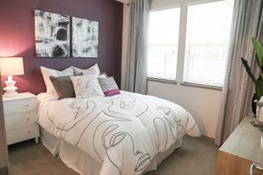 Sacramento apartment for rent - a bedroom with a bed and a purple accent wall