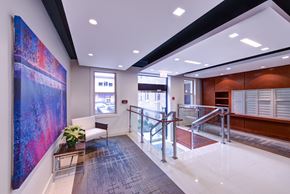 Washington apartment for rent - a lobby with a large painting on the wall and a staircase