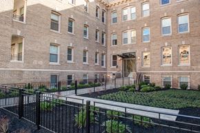 Washington apartment for rent - a large brick building with a garden in front of it