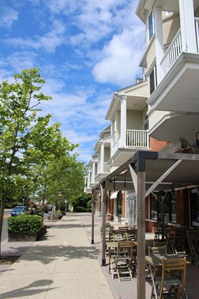 Garwood apartment for rent - a sidewalk in front of a row of buildings with tables and chairs