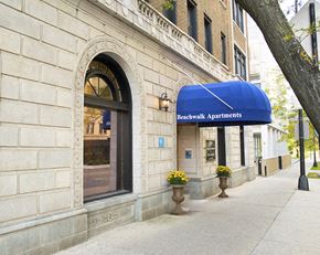 Chicago apartment for rent - the front of a building with a blue awning and a sidewalk