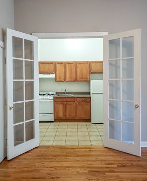 Chicago apartment for rent - an empty kitchen with white appliances and wooden cabinets