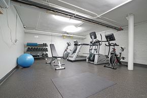 Chicago apartment for rent - a gym with cardio equipment and weights in a building