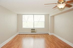 Evanston apartment for rent - an empty living room with a ceiling fan and a window