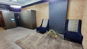 Evanston apartment for rent - a lobby with two blue chairs and a glass table