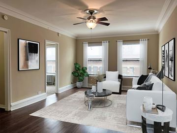 Chicago apartment for rent - a living room with white furniture and a ceiling fan