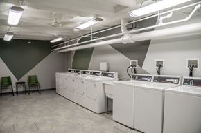 Chicago apartment for rent - a group of washers and dryers in a room with a green chair