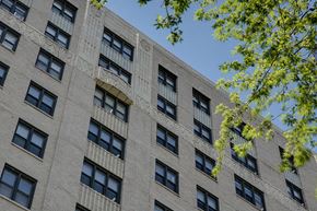 Chicago apartment for rent - a large brick building with many windows and a tree